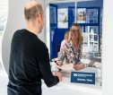 A member of staff smiling and greeting a customer at area office 