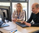 A female agricultural officer helping a male customer at a computer