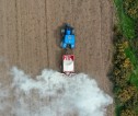 Aerial photograph of a tractor spreading lime on farmland.