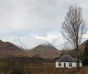 Image of small house in foreground with snowy mountain in the background
